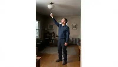 Albany, NY electrician conducts a home lighting consultation beside an existing ceiling fixture