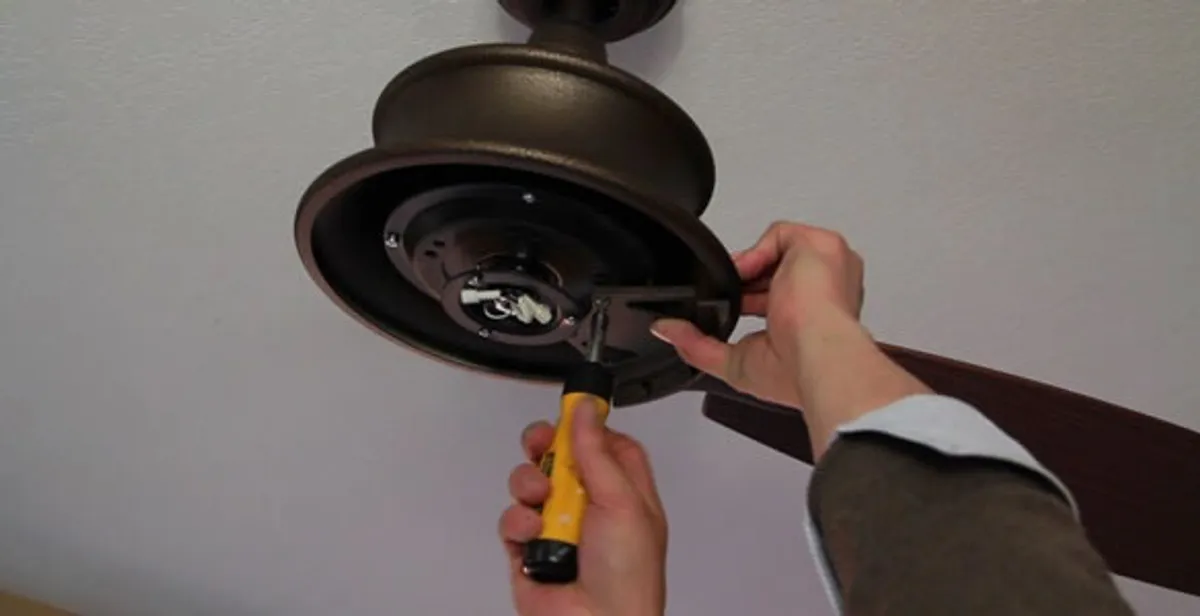 Electrician installing ceiling fan mounting bracket and fixture in Albany, NY