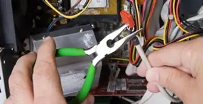 Licensed electrical contractor performing electrical repair with tools in Guilderland, NY