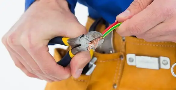licensed electrician securing electrical wiring with professional tools during service work in Albany, NY