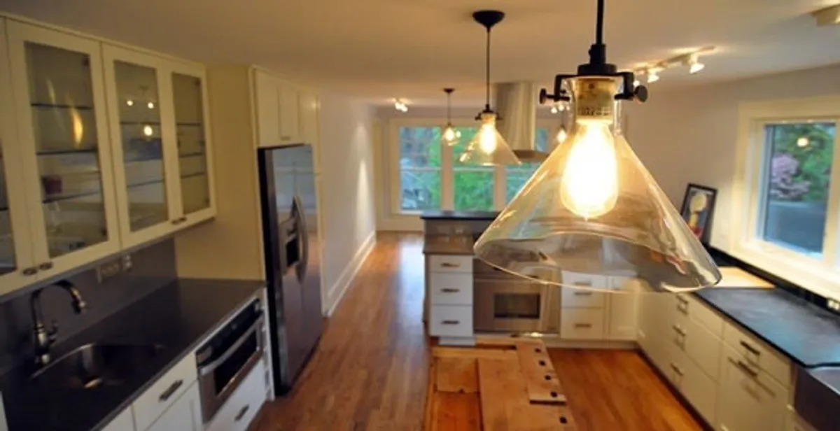 Residential electrician installing modern indoor light fixture in a home in Albany, NY