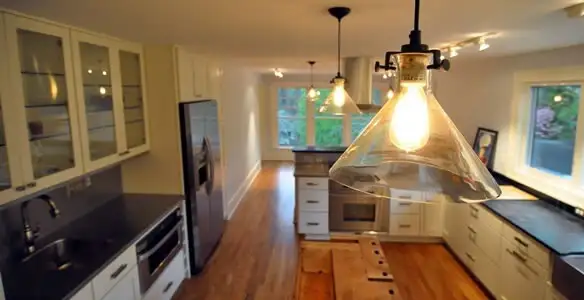 Residential electrician installing modern indoor light fixture in a home in Albany, NY
